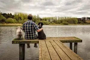 man and dog hugging