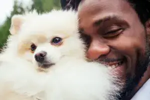 man hugging fluffy dog