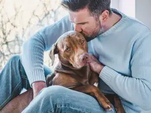 man kissing dog